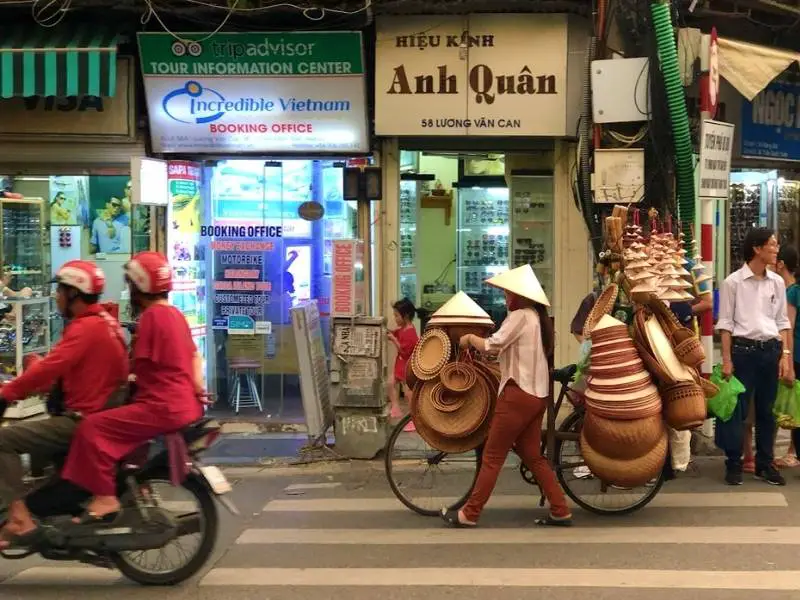 Vietnamese woman carrying non la on her bike in Hanoi, Vietnam